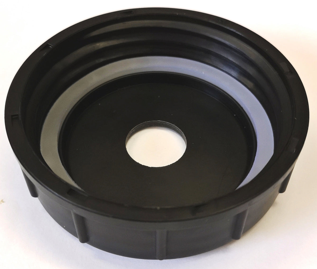 A black circular plastic component with a central hole and a gray inner ring, photographed on a plain white background.